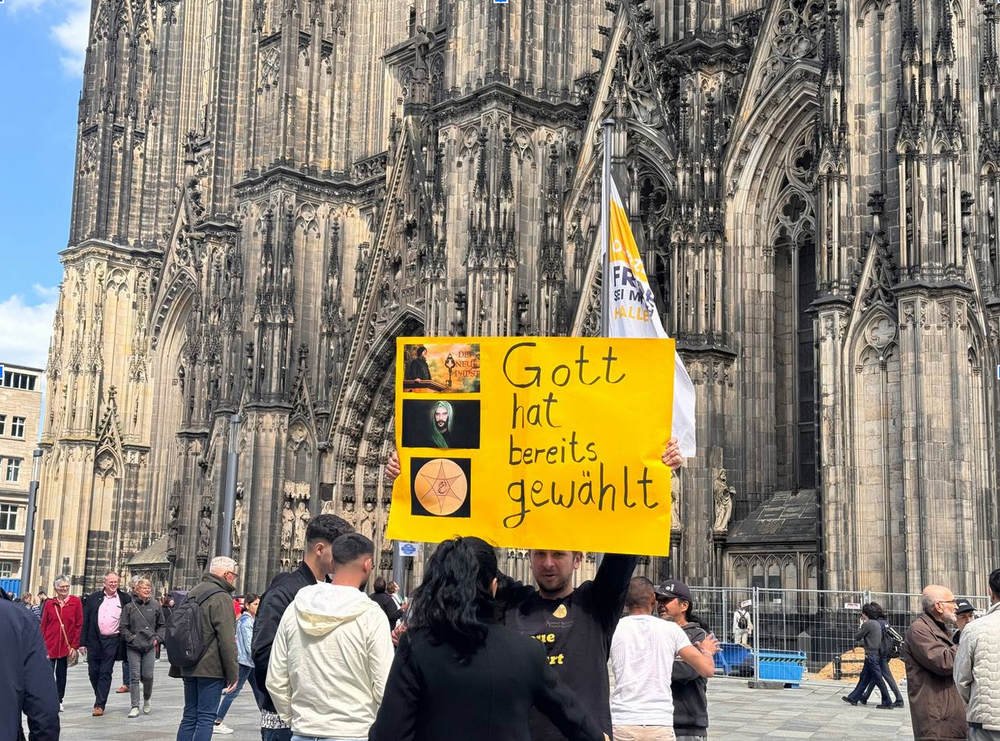 Une affiche brandie devant la cathédrale de Cologne