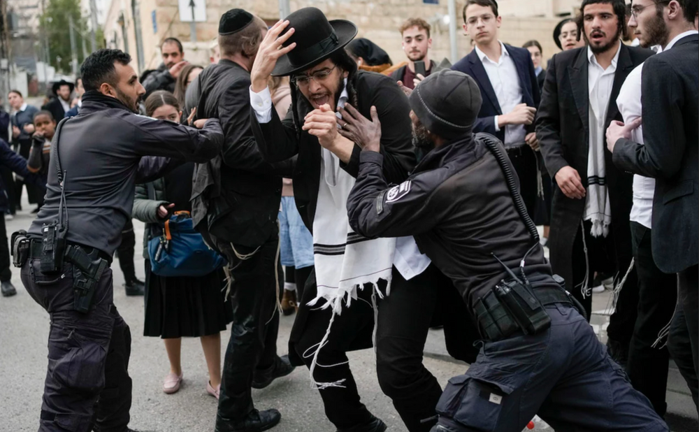 La police israélienne disperse des hommes et des garçons juifs ultra-orthodoxes qui bloquaient une route lors d’une manifestation contre la conscription militaire du pays, à Jérusalem, le 26 février. CREDIT: LEO CORREA/AP