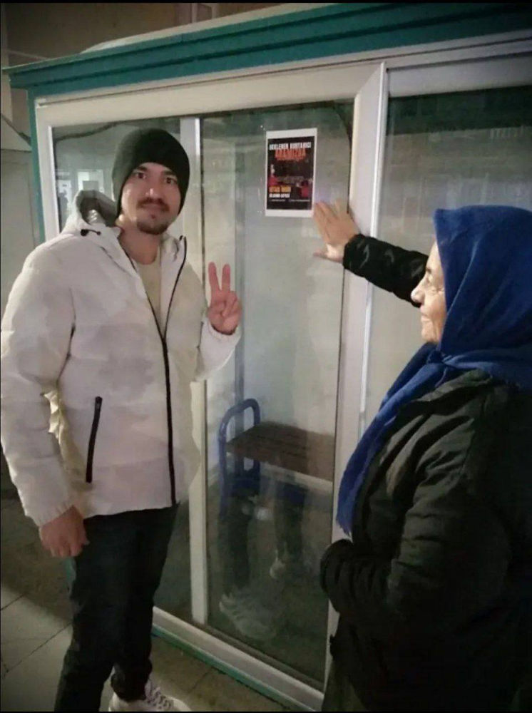 un homme appose une affiche d’Aba Al-Sadiq en Turquie