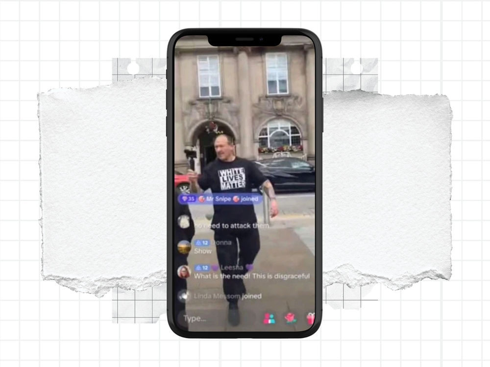 Un homme en tee-shirt « White Lives Matter » parle au téléphone lors d’un direct devant un bâtiment en pierre, des commentaires de discussion se superposant à l’image.