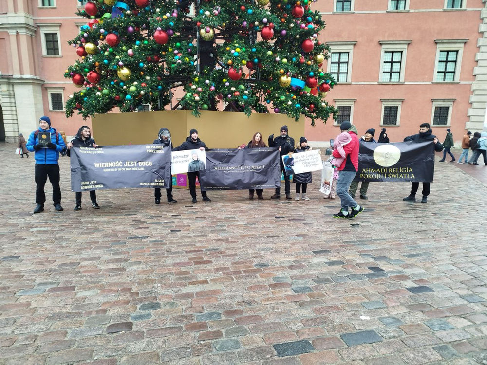 Des Ansar d’origines diverses — azerbaïdjanaise, thaïlandaise, jordanienne et polonaise — défilent place du Château, à Varsovie, en Pologne, en portant l’appel à l’allégeance divine, le 26 décembre 2025.