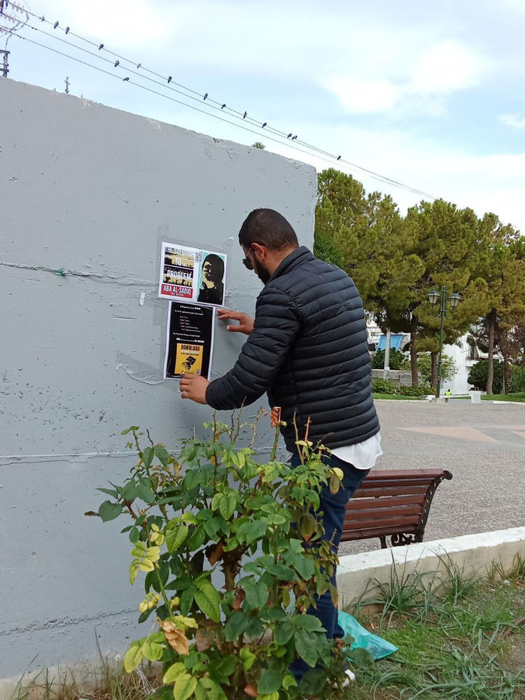 Un membre jordanien de la Religion ahmadie de la paix et de la lumière diffuse des affiches en Grèce