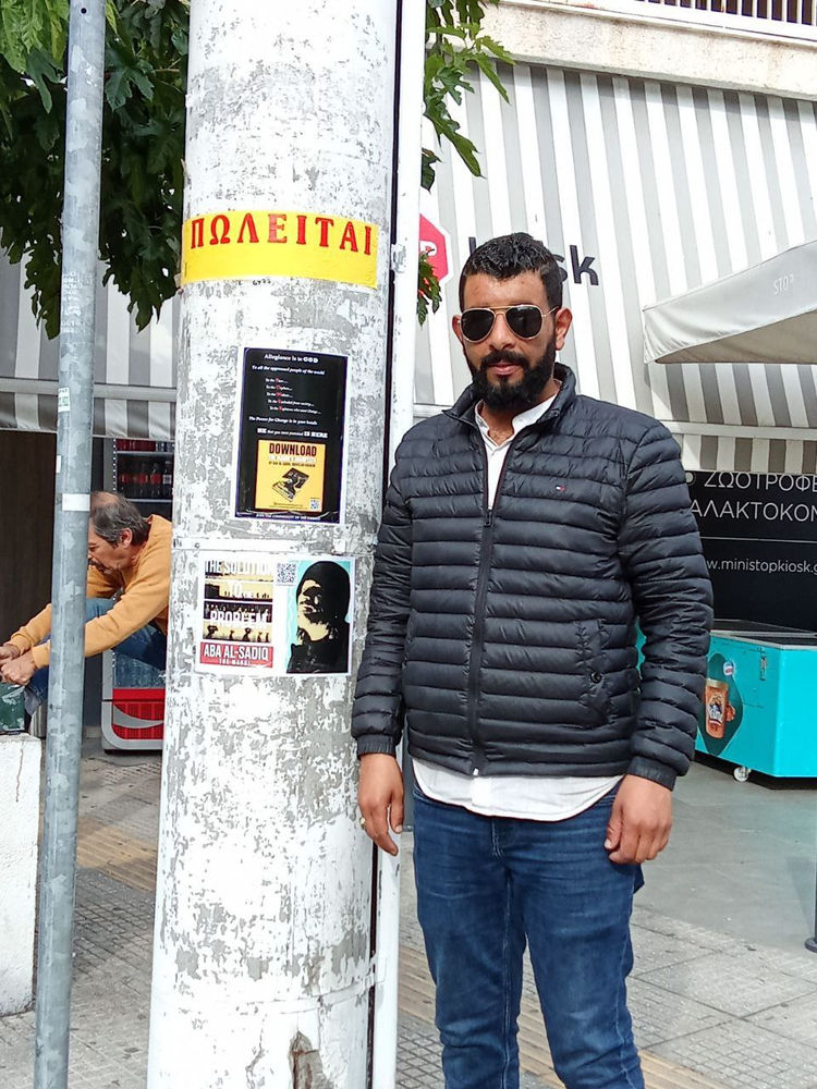 un croyant en Aba Al-Sadiq pose des autocollants à Athènes
