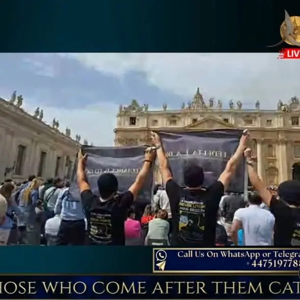 des croyants lèvent un drapeau noir au Vatican pendant la messe de Pâques