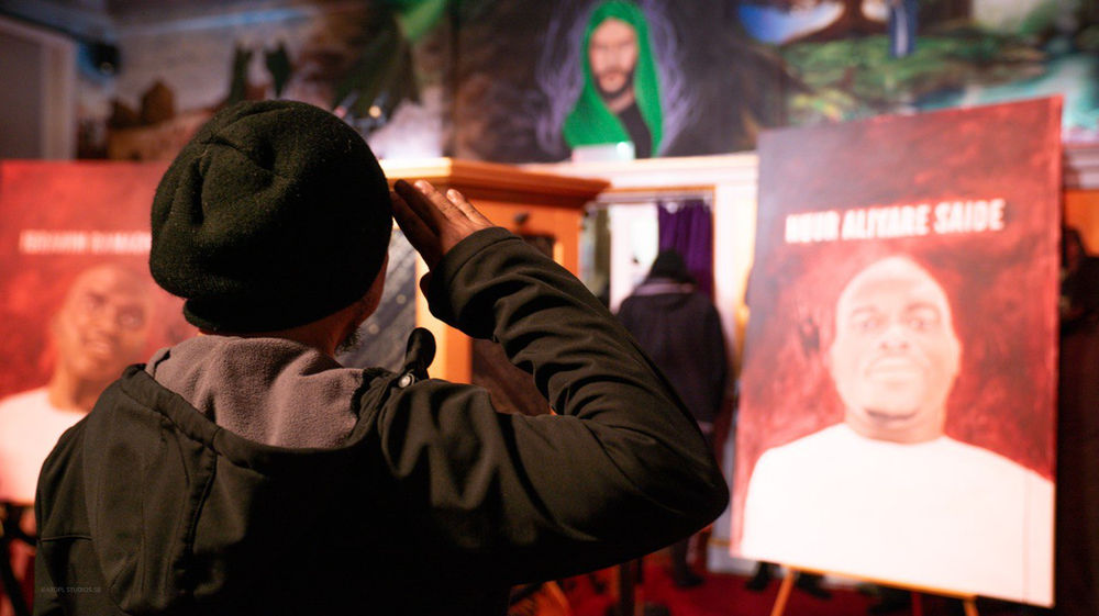 un croyant de l’AROPL salue le portrait d’un martyr